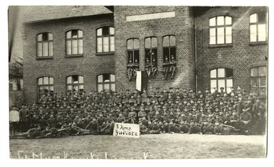 Styczeń 1919 roku. Druga Grodziska Kompania Powstańcza, późniejsza 5 kompania II batalionu 2 pułku strzelców wielkopolskich przed budynkiem dzisiejszej Szkoły Podstawowej nr 2 w Grodzisku Wielkopolskim.
